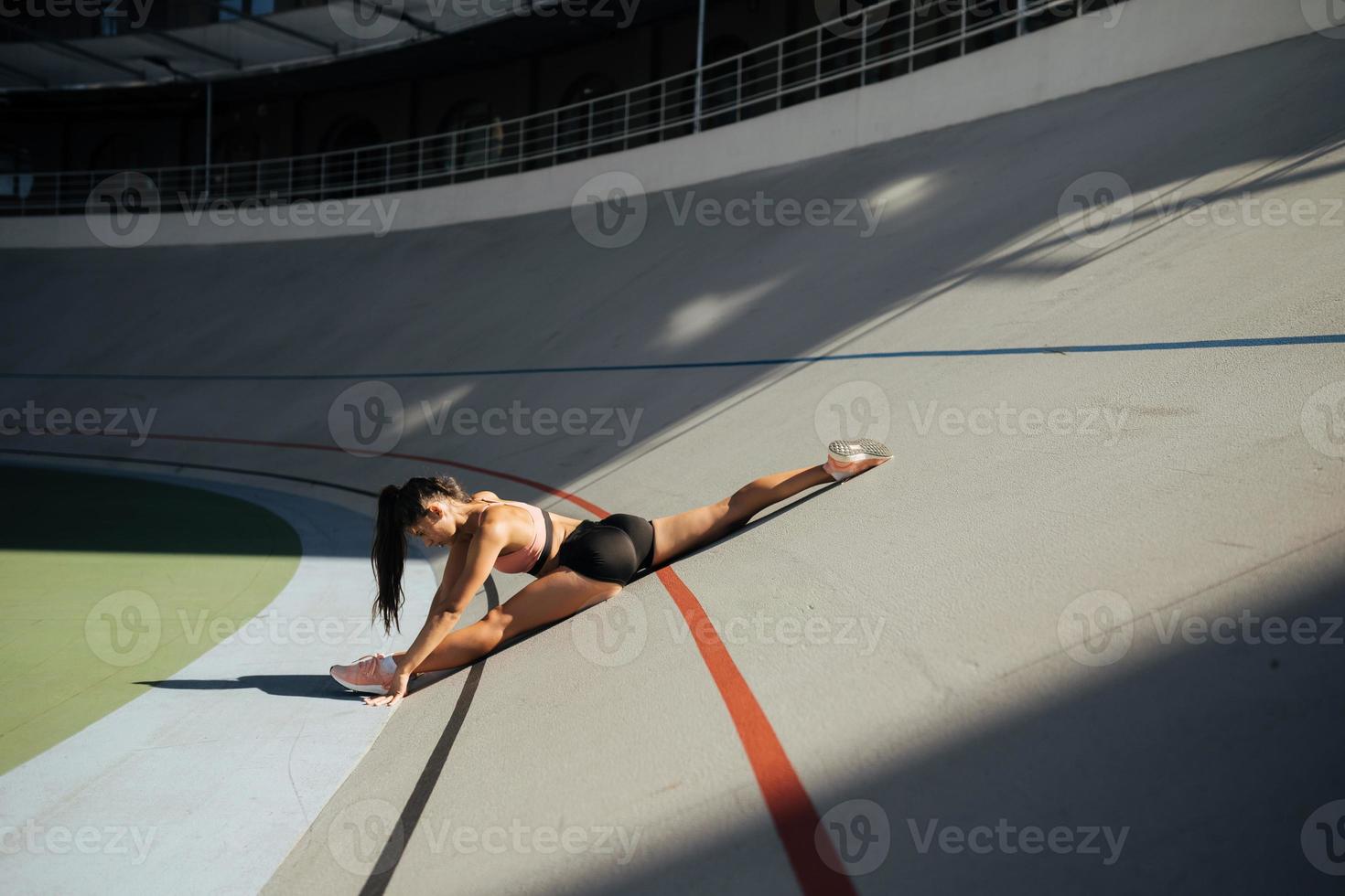 Young attractive female fitness woman performing a twine photo