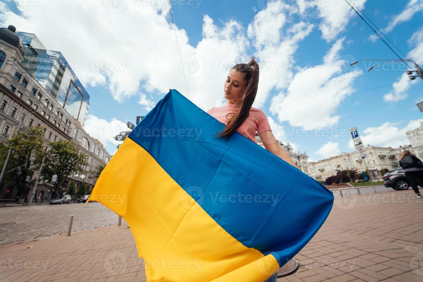 mujer joven con bandera nacional de ucrania en la calle foto