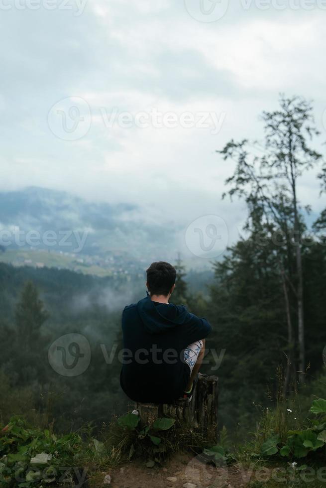 Guy top of a hill enjoying view of nature photo