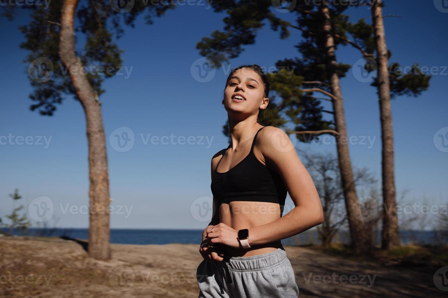 Fitness young woman walks in the park and posing for the camera photo