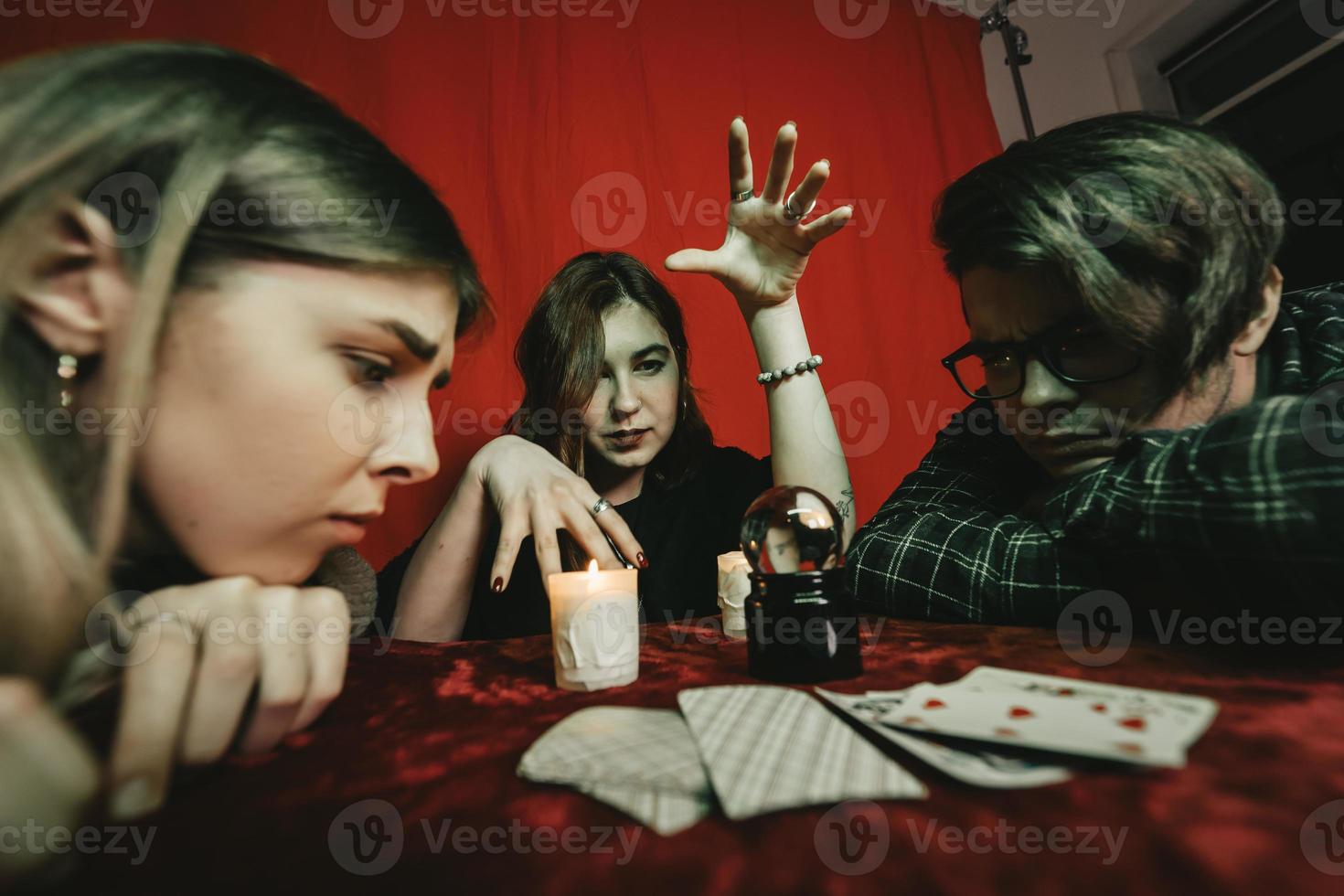 Group of people and woman fortune teller with crystal ball photo