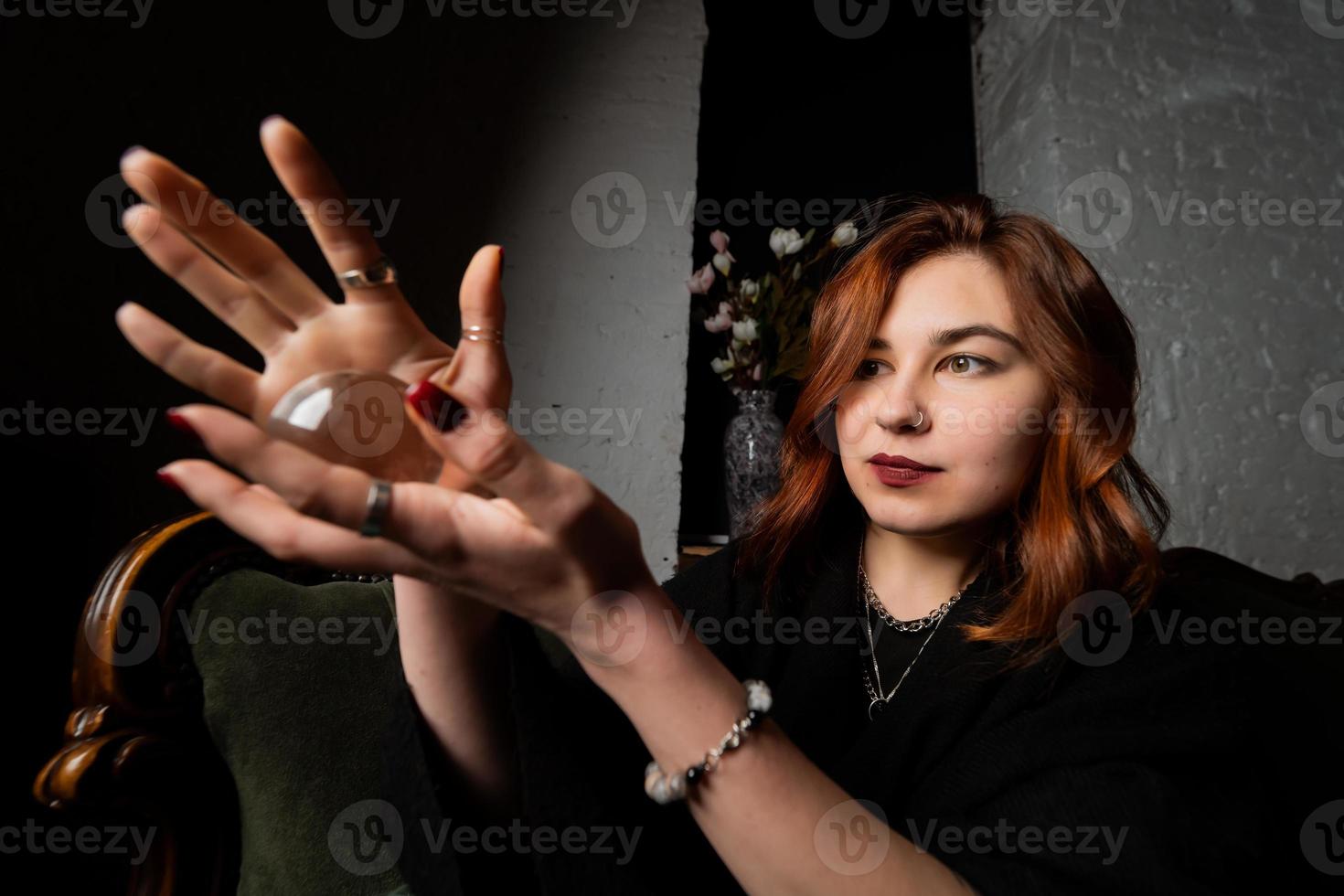 Woman in black suit holding crystal ball photo