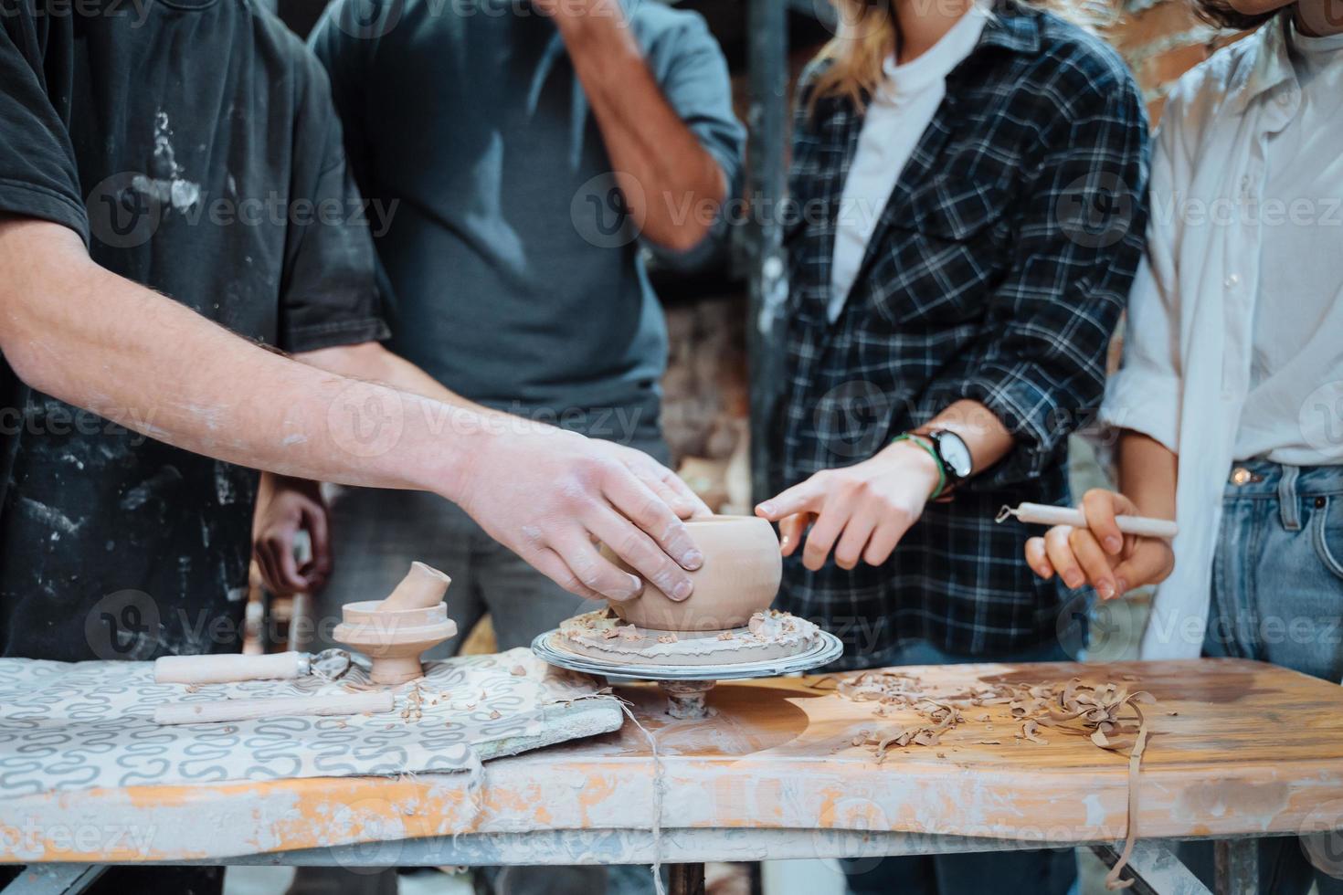 Making a handmade clay pot in the workshop. Pottery lesson with master. photo