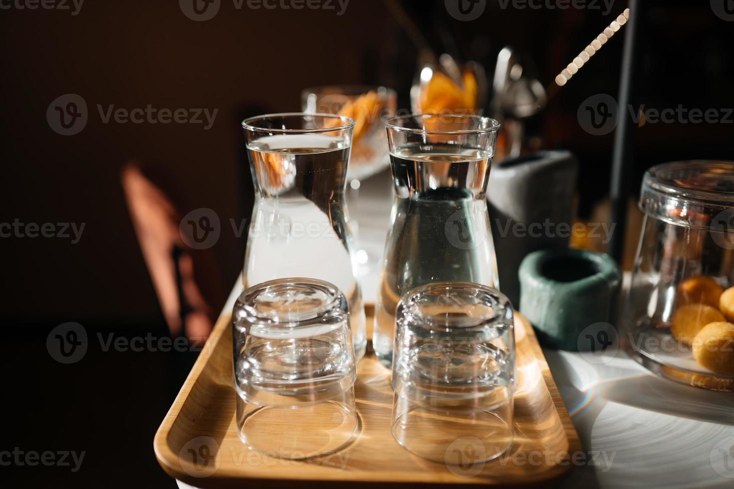 Four glass cups on the bar counter with serving accessories. photo