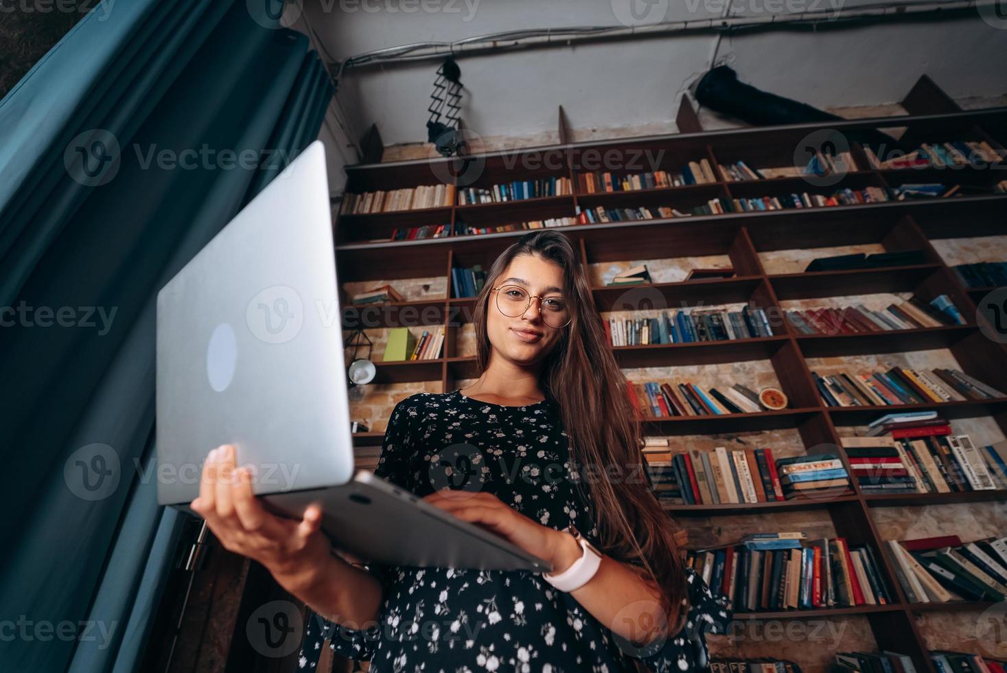 Young woman holding a laptop opening in her hands. photo