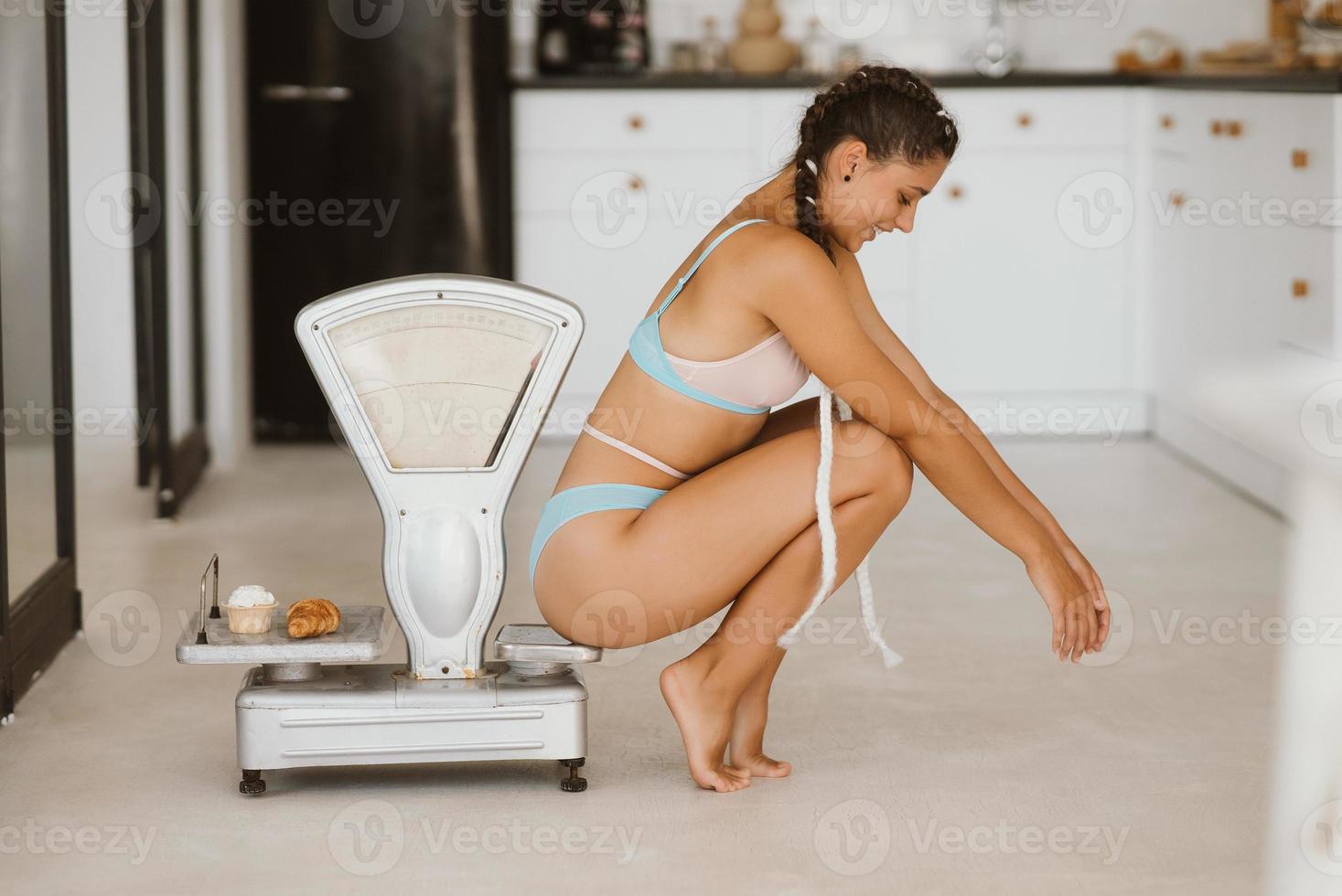 Woman in lingerie posing at the old grocery scales. Healthy eating concept photo