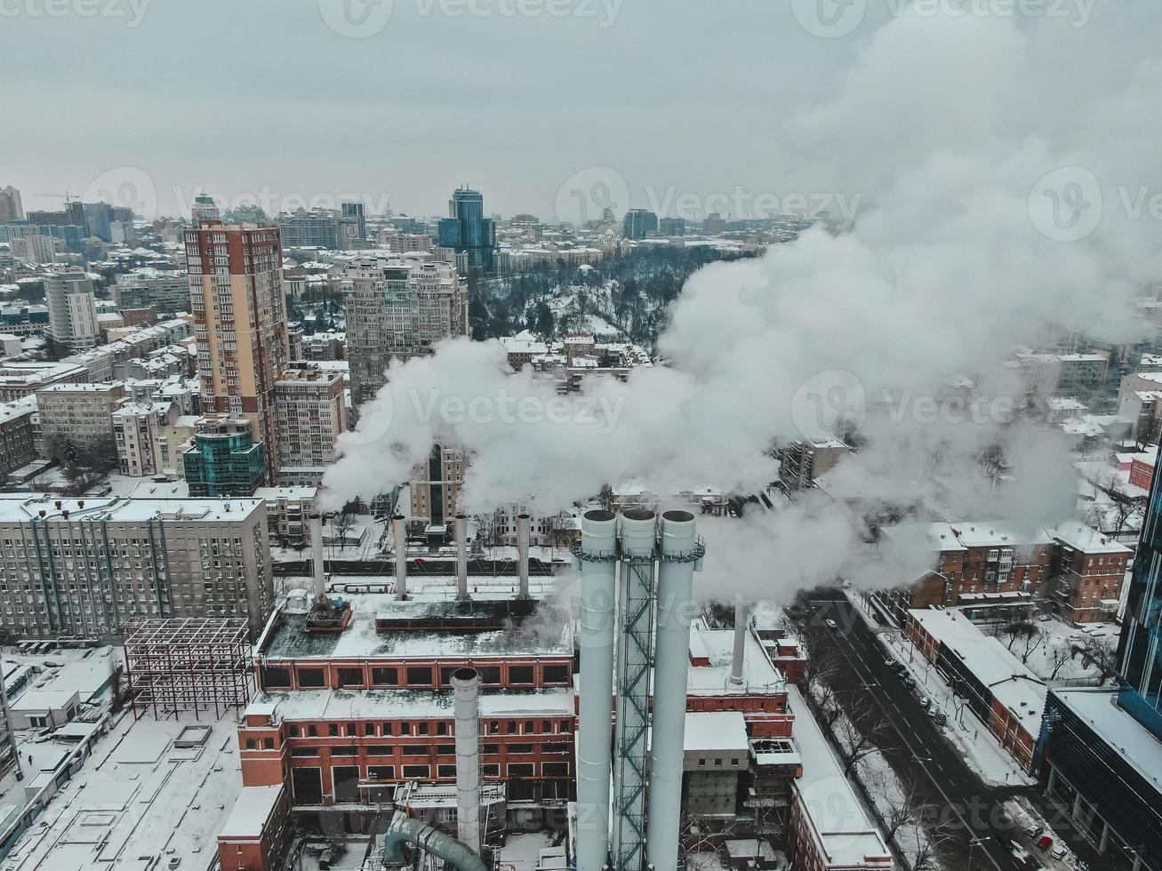 Large central boiler room with giant pipes of which there is dangerous smoke in winter during frost in a big city photo