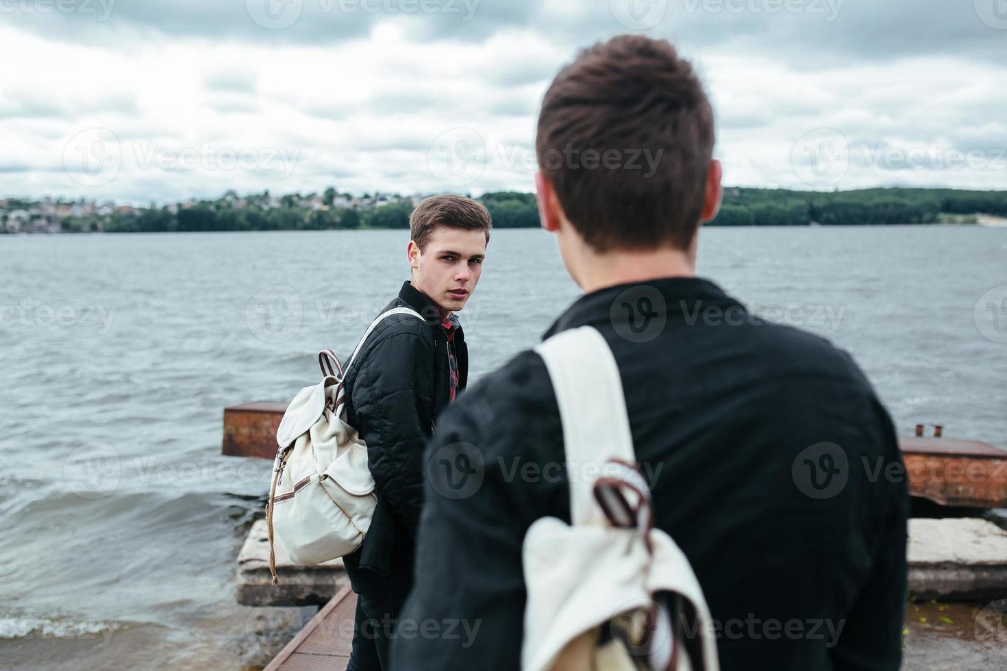 two young guys standing on a pier photo