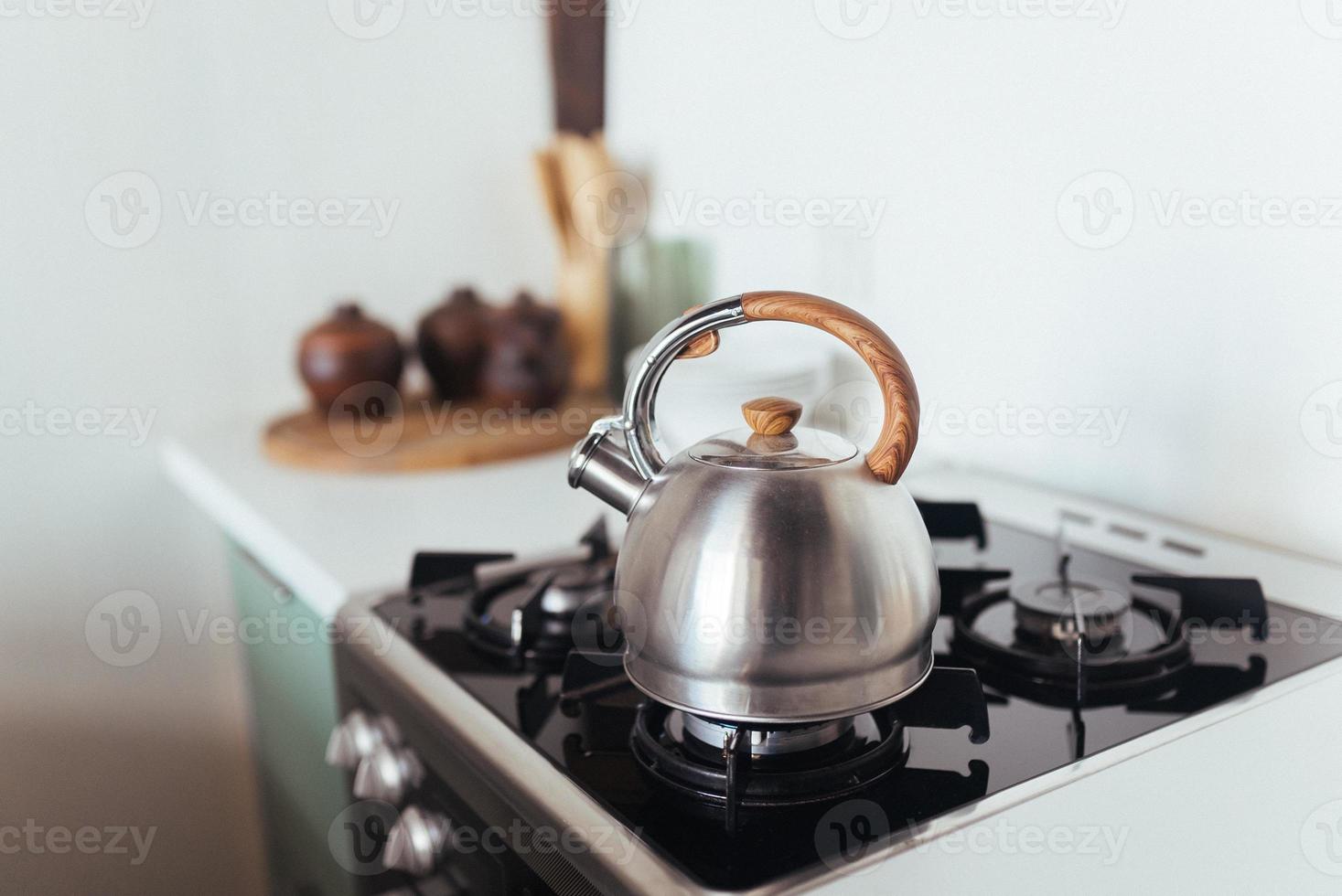 tetera en la estufa de gas. interior de la cocina moderna foto