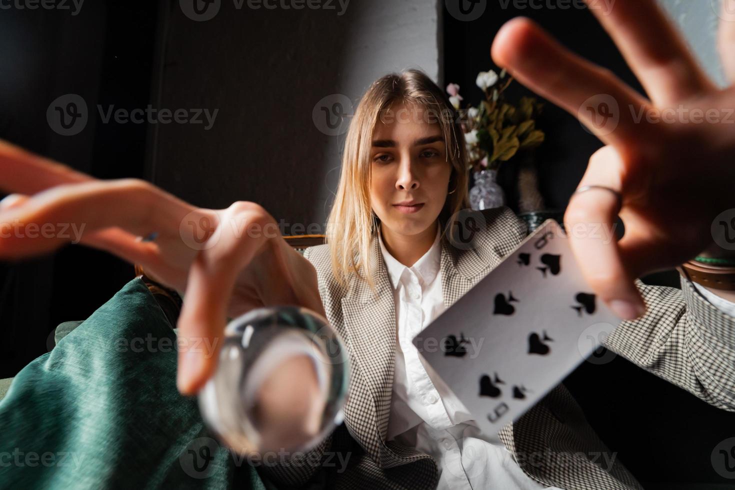 Woman in business suit holding crystal ball and six spade photo