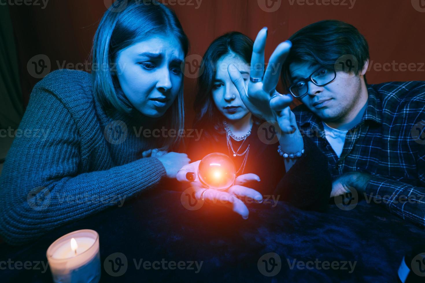 grupo de personas y mujer adivina con bola de cristal foto