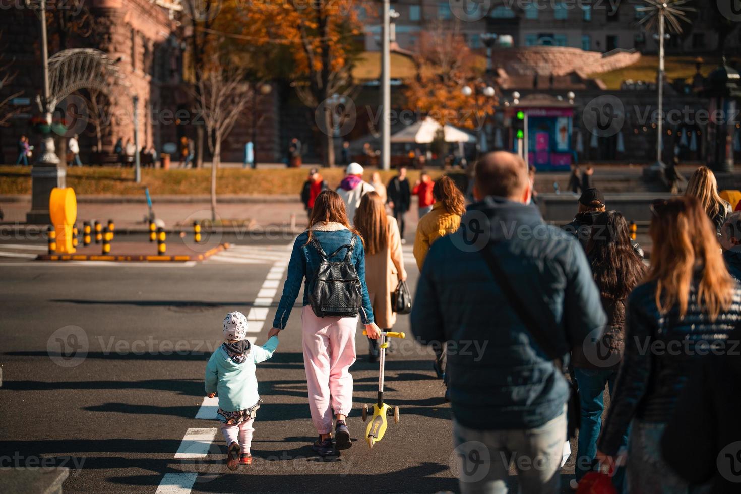 Lots of people crossing the street at the traffic lights. photo