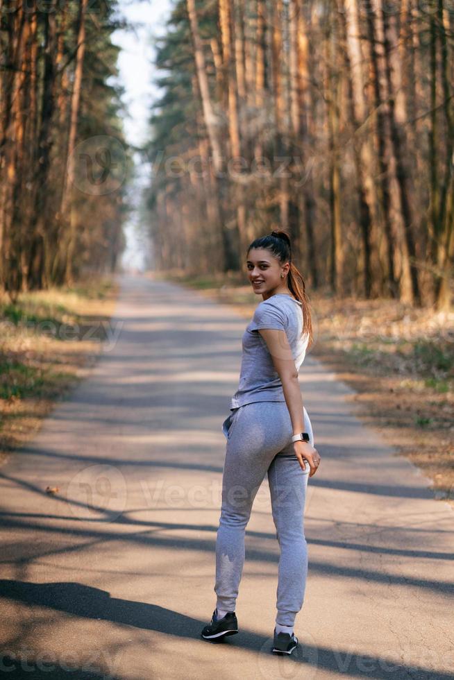 Fitness young woman walks in the park and posing for the camera photo
