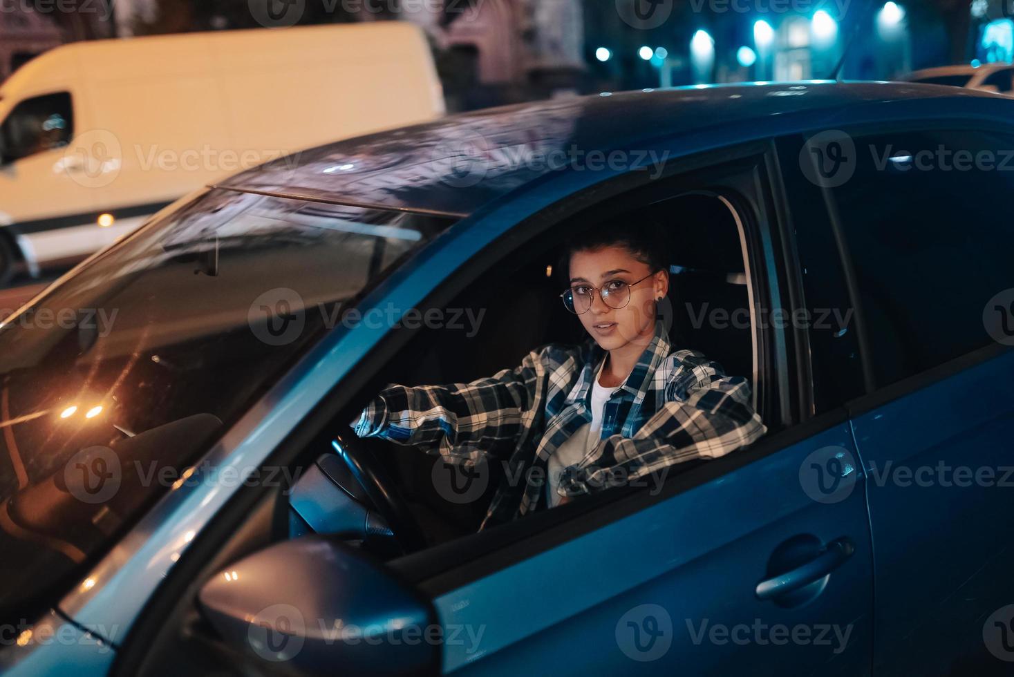 Woman driving car by night in the city photo
