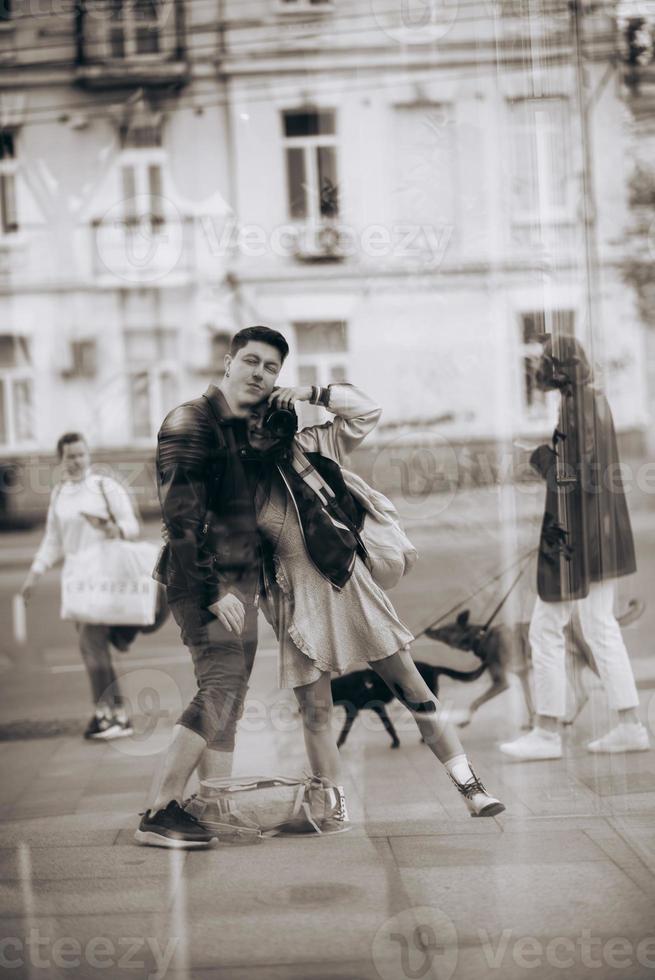 pareja joven tomando selfie en reflejo del edificio de vidrio foto