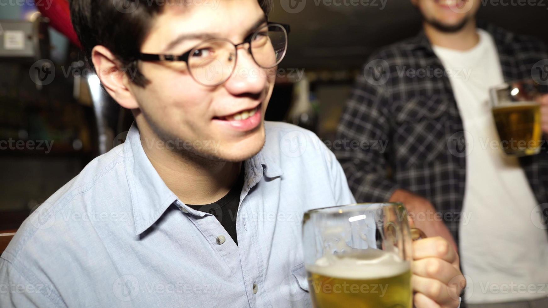 Guy with a beer in a bar with friends on a Saturday night photo