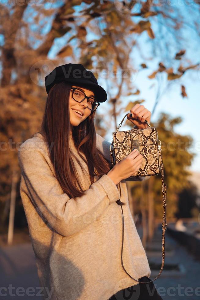 Beautiful young girl with handbag posing on camera photo
