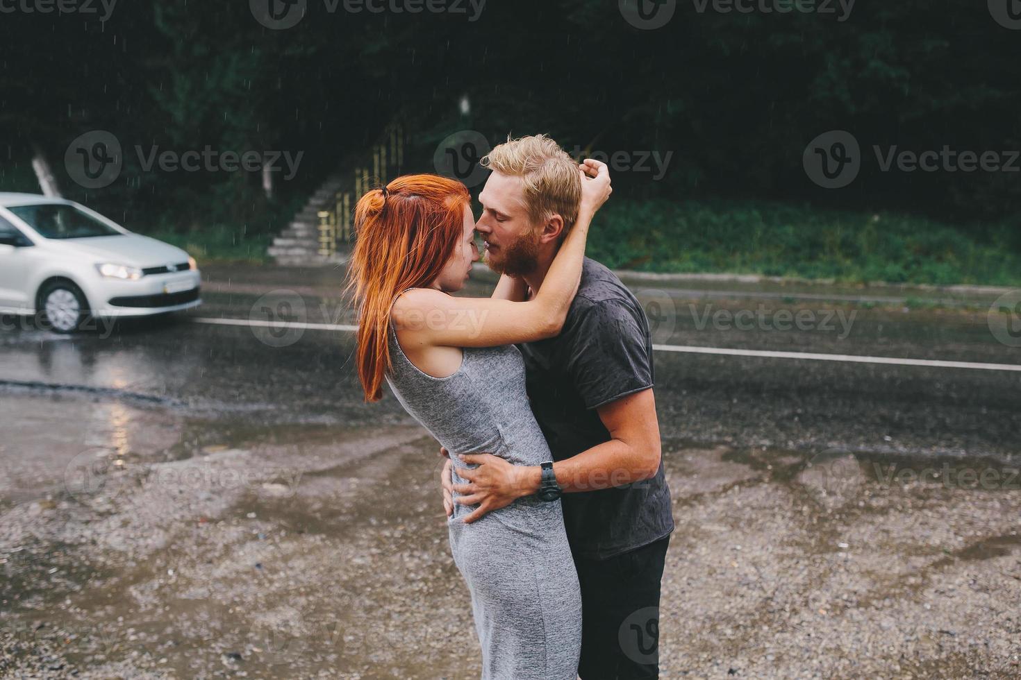 beautiful couple hugging in the rain photo