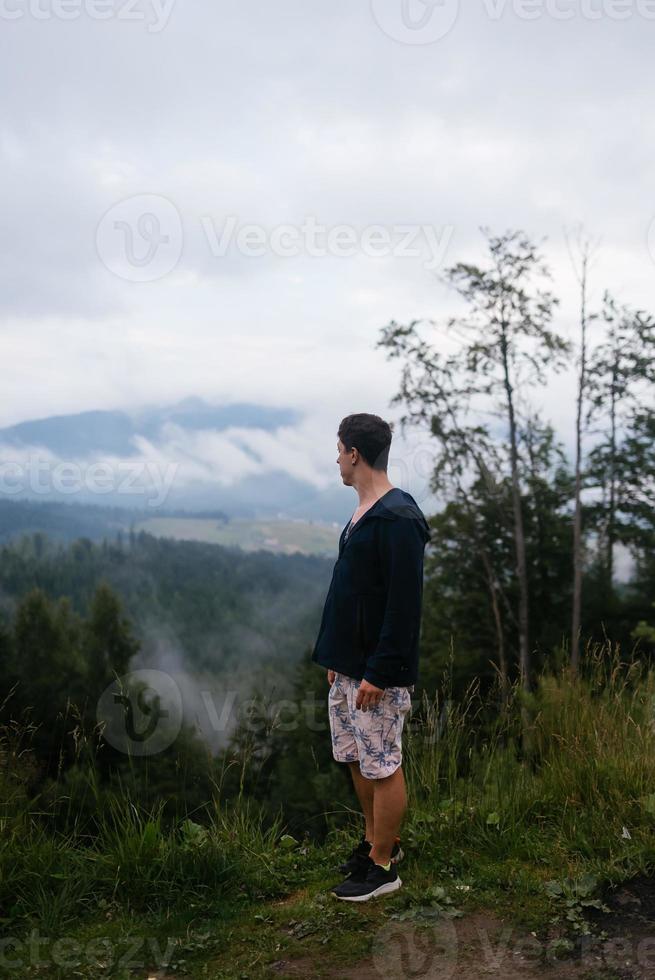 chico en la cima de una colina disfrutando de la vista de la naturaleza foto