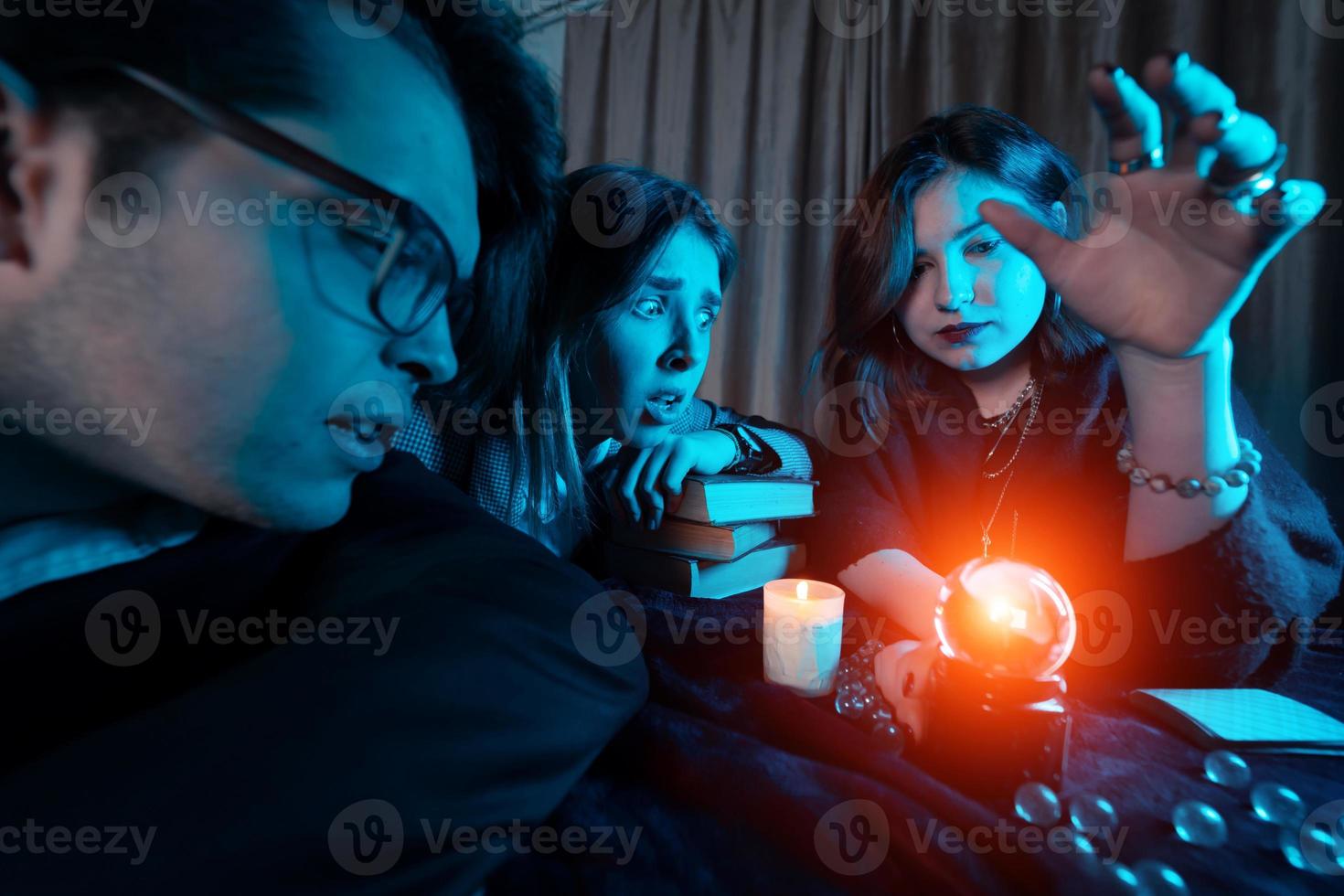 Group of people and woman fortune teller with crystal ball photo