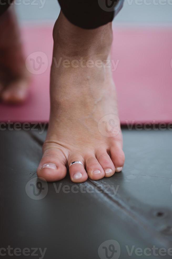 Cerrar detalle de pies de mujer durante el ejercicio de yoga. foto