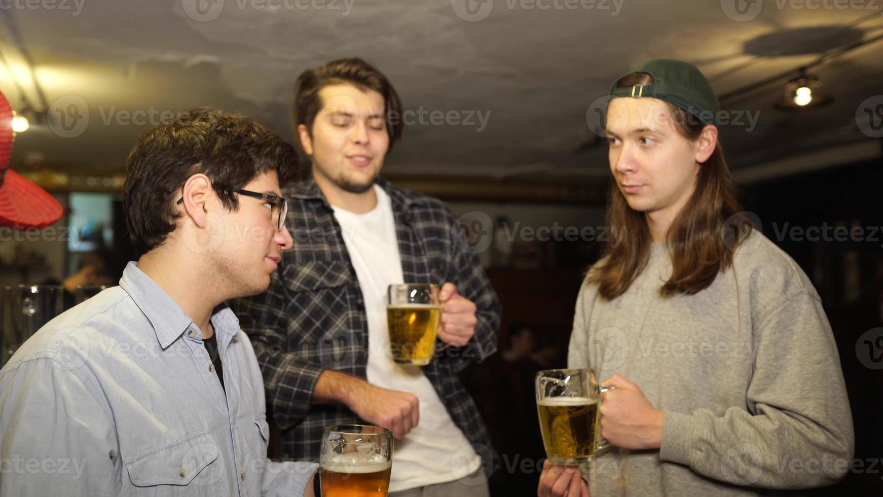 Young friends having fun together drinking beer in a pub. photo