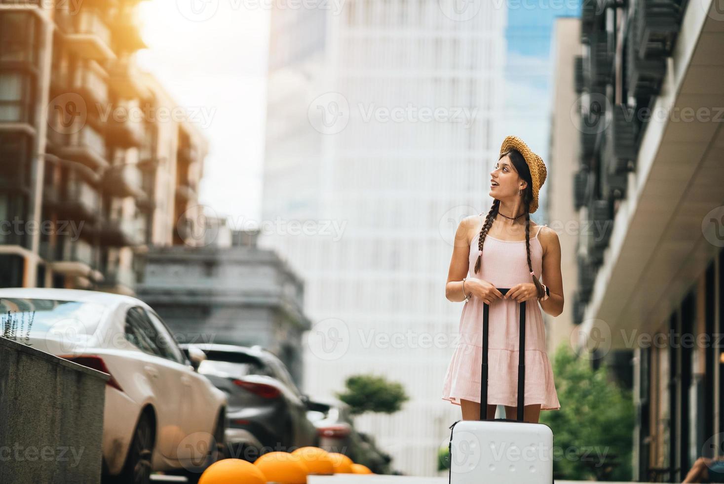 Young woman with suitcase and looks to the side photo