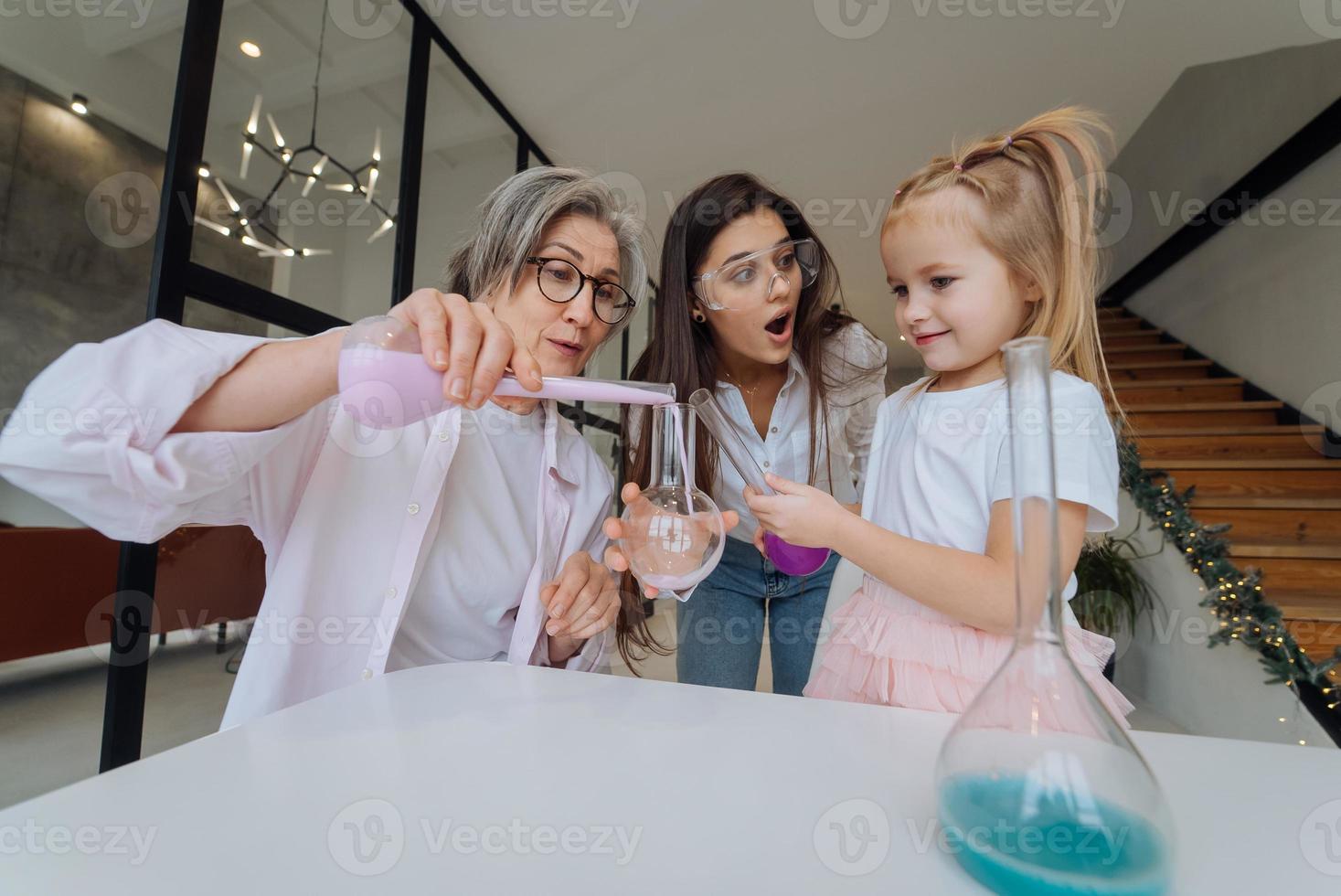 Family doing chemical experiment, mixing flasks indoors photo