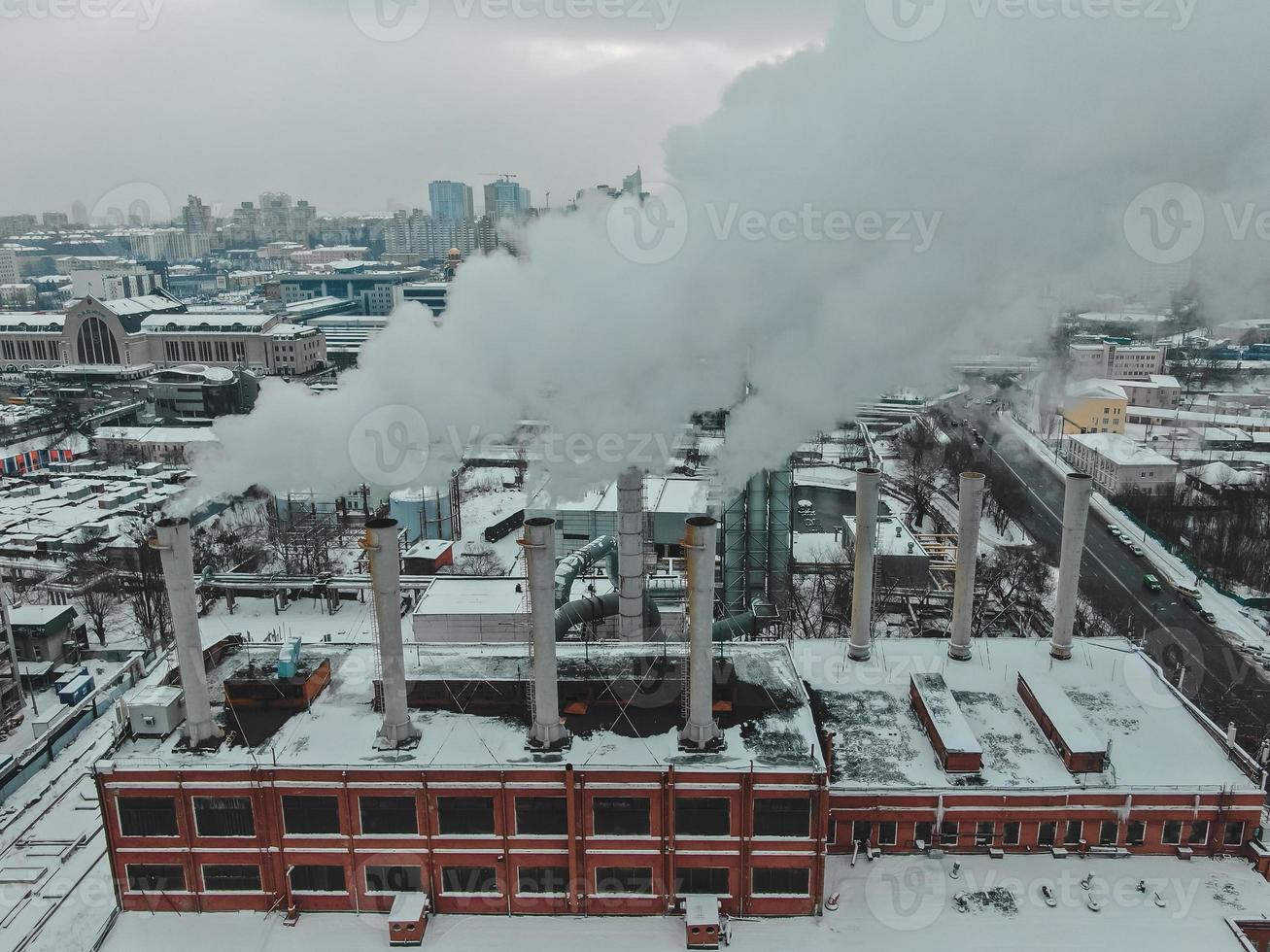 Large central boiler room with giant pipes of which there is dangerous smoke in winter during frost in a big city photo