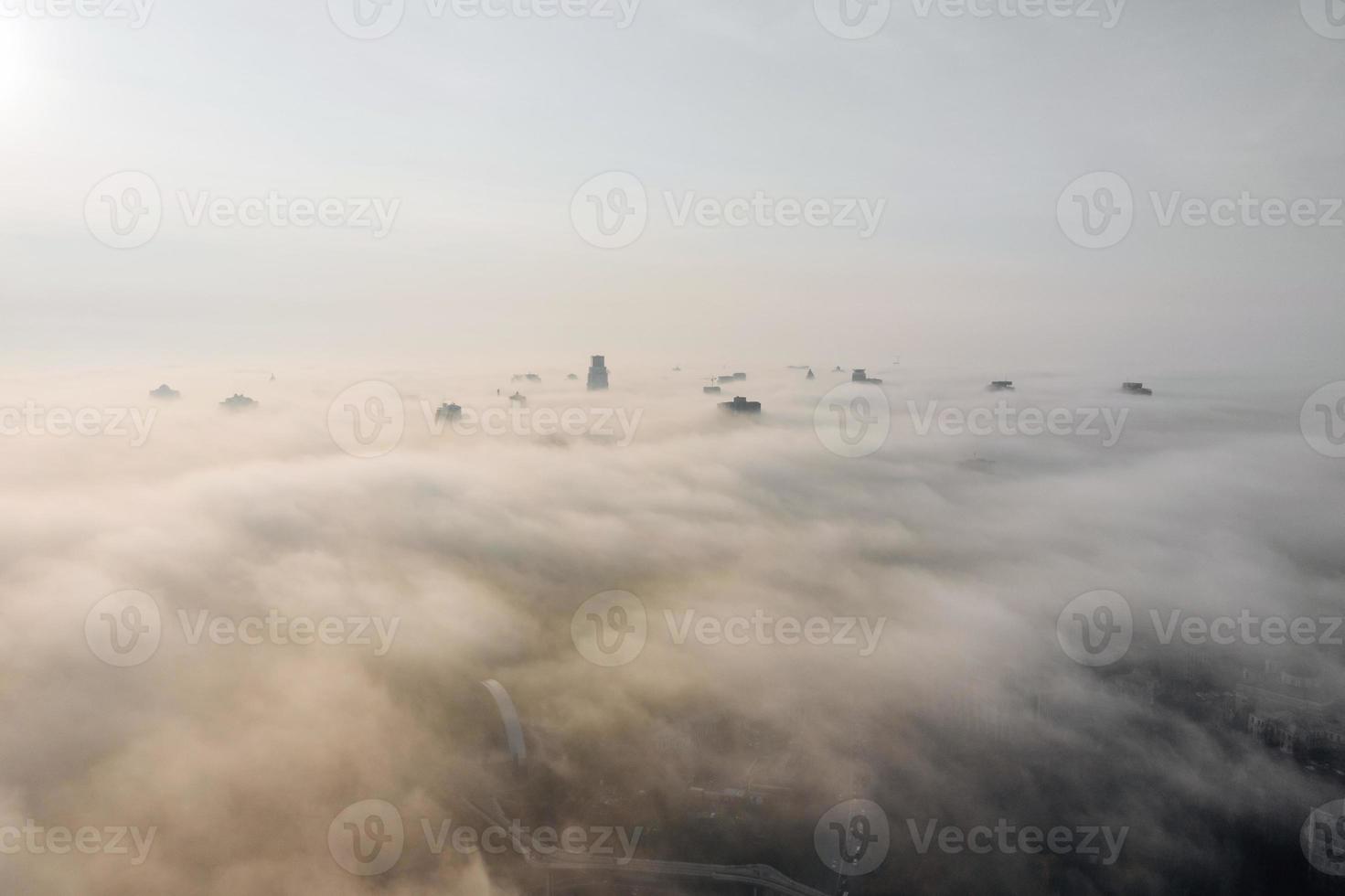 Aerial view of the city in the fog. Skyscrapers above the fog photo