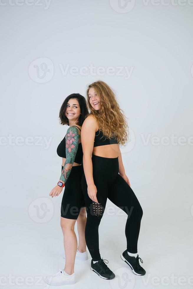 Two young women posing over white background. photo