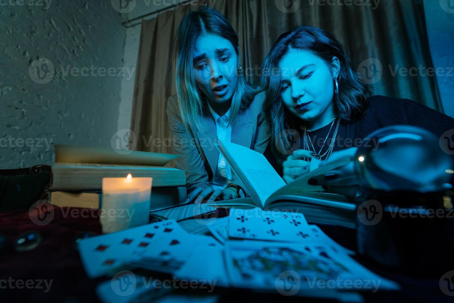 dos mujeres están leyendo un libro misterioso foto