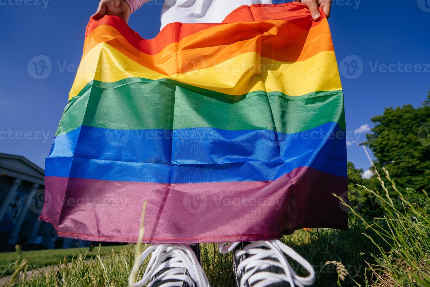 Cropped photo of young woman with LGBT pride flag.