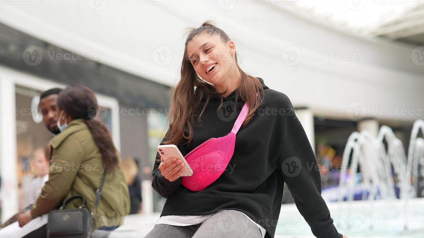 Woman using smartphone indoor. Texting and communicating in mall photo
