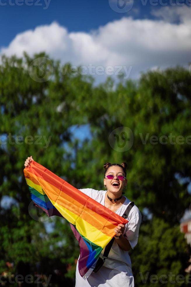 Young woman holding an LGBT pride flag in her hands. photo