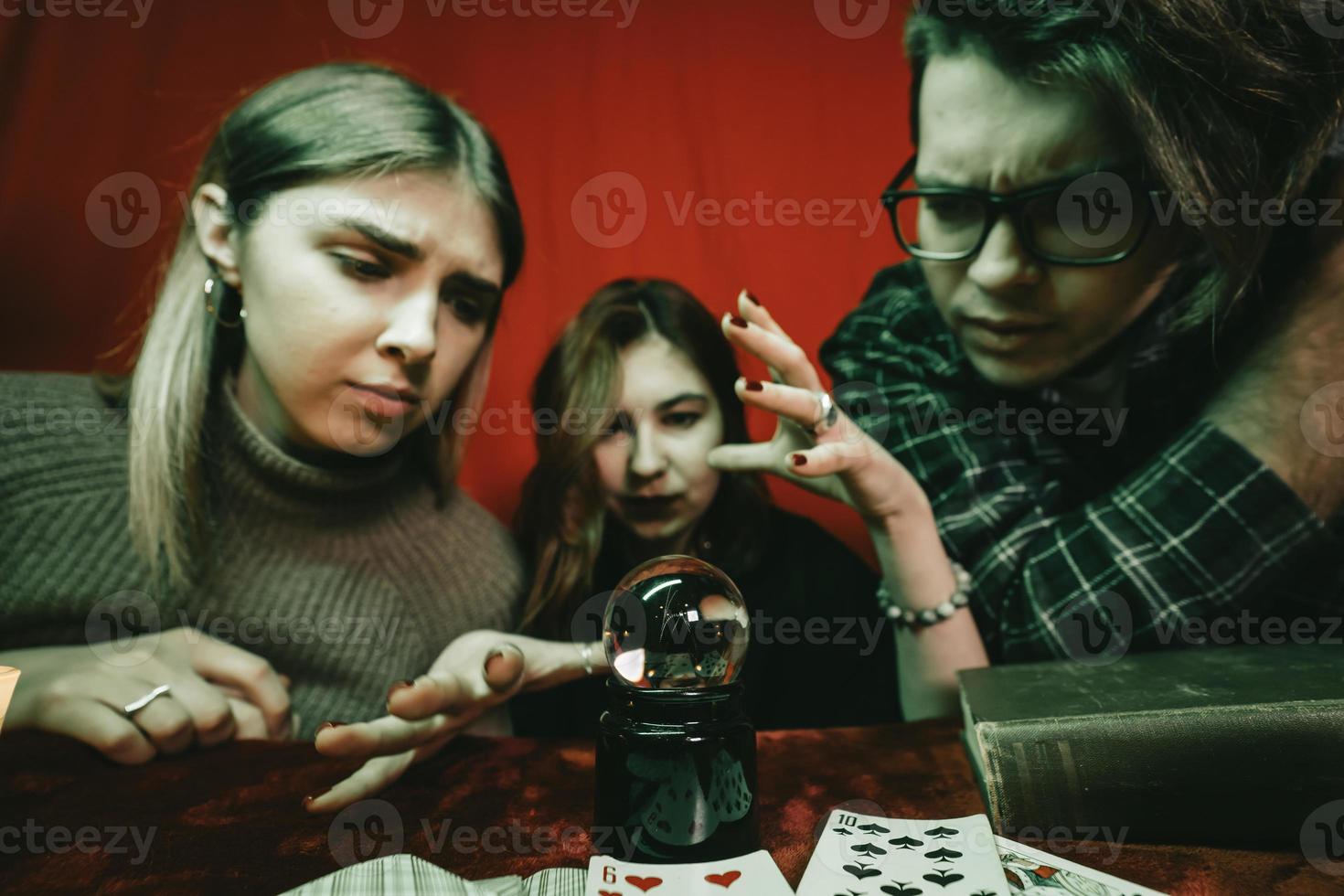 Group of people and woman fortune teller with crystal ball photo
