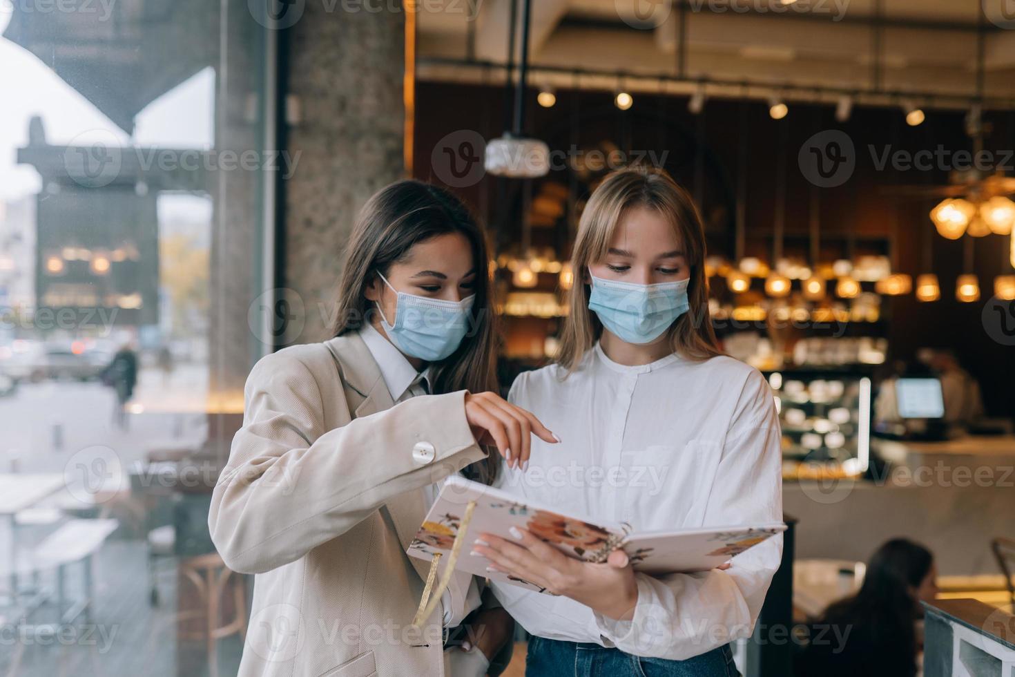 two businesswomen with their face masks debating different views on work photo