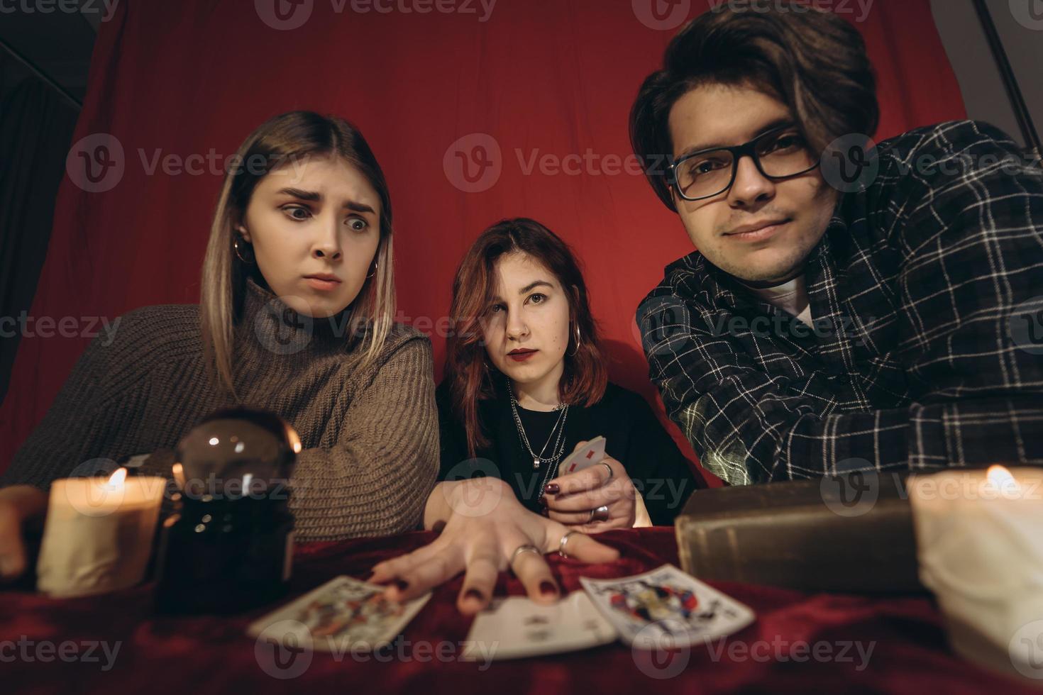 Group of people and woman fortune teller with crystal ball photo