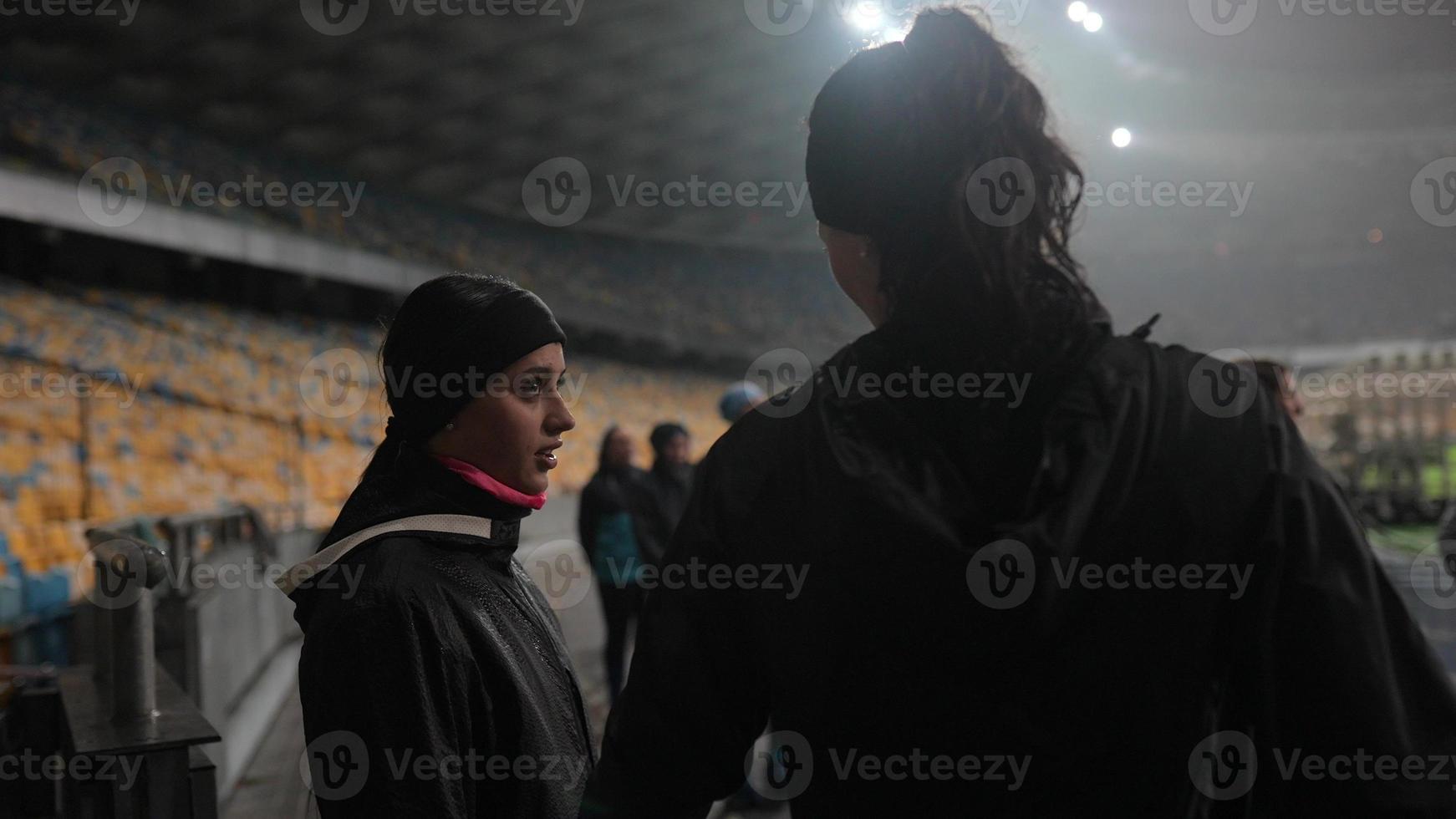 People go in for sports at night stadium in rainy weather photo