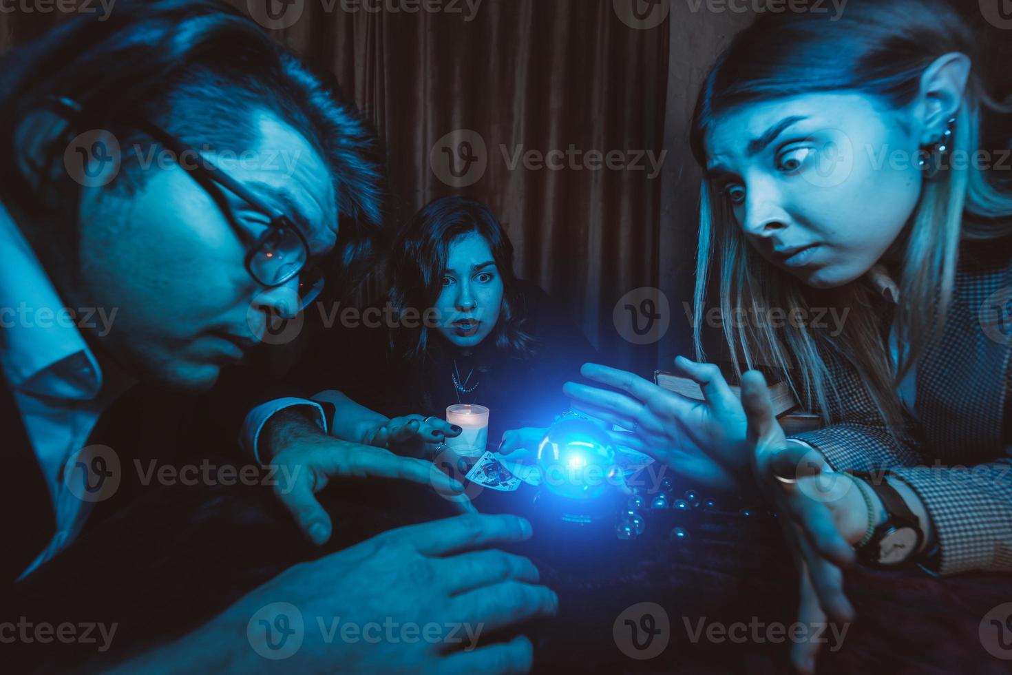 grupo de personas y mujer adivina con bola de cristal foto