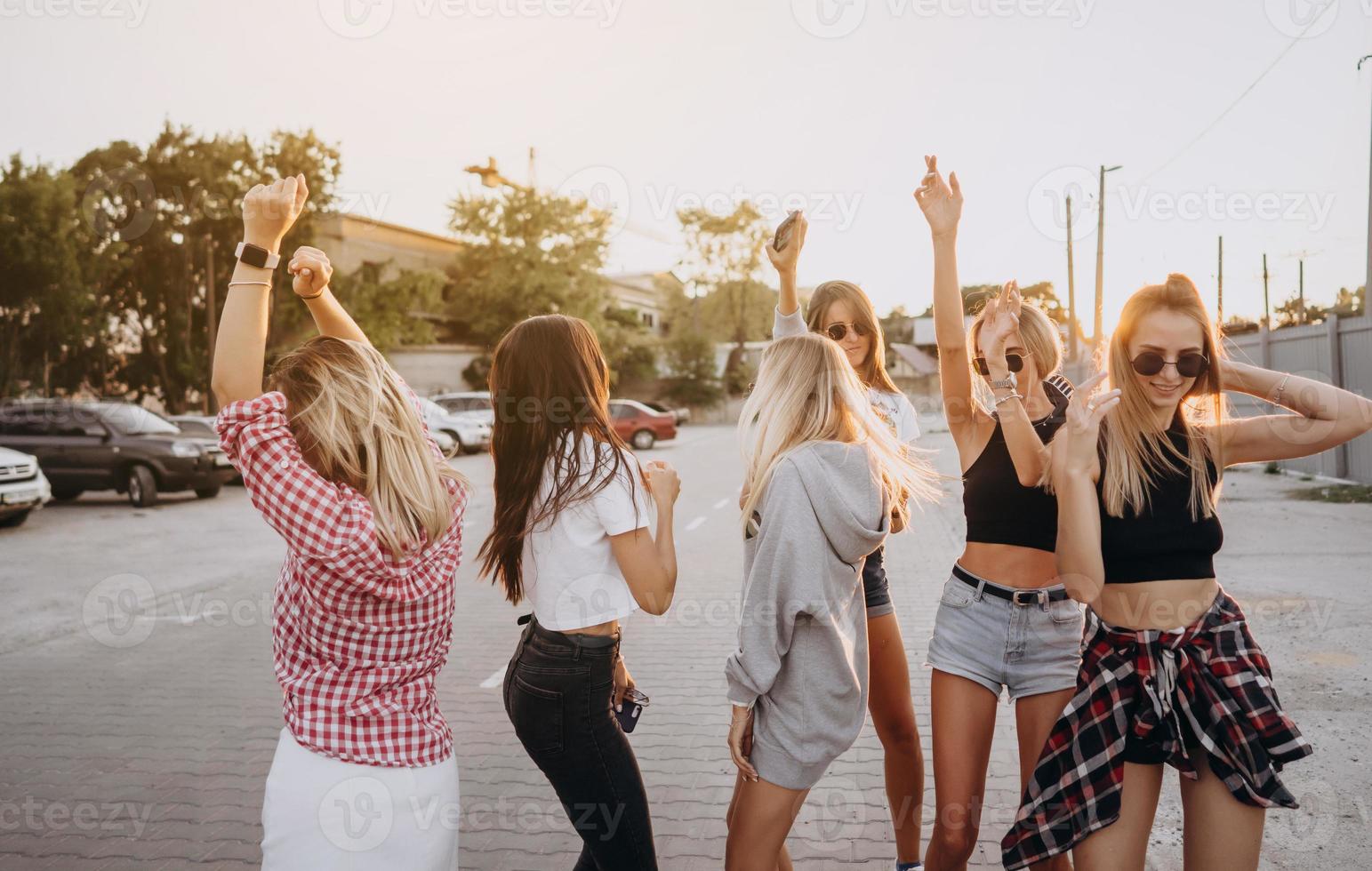 Six young women dance in a car park photo