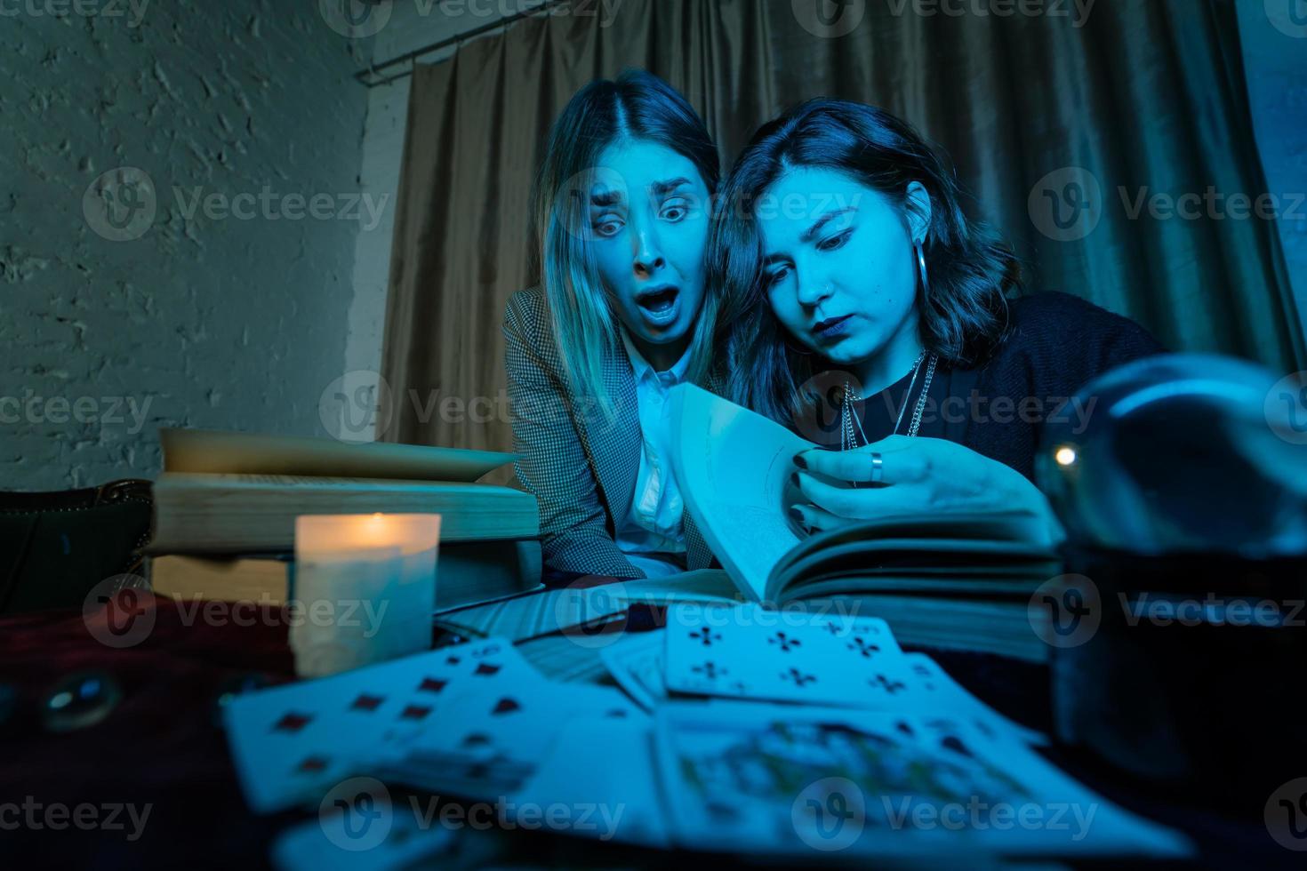 dos mujeres están leyendo un libro misterioso foto