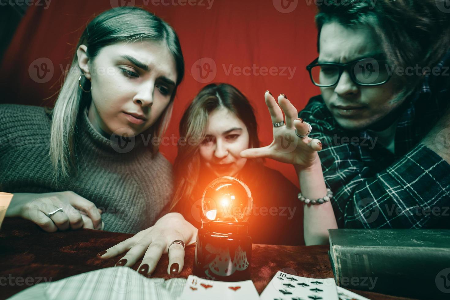 grupo de personas y mujer adivina con bola de cristal foto