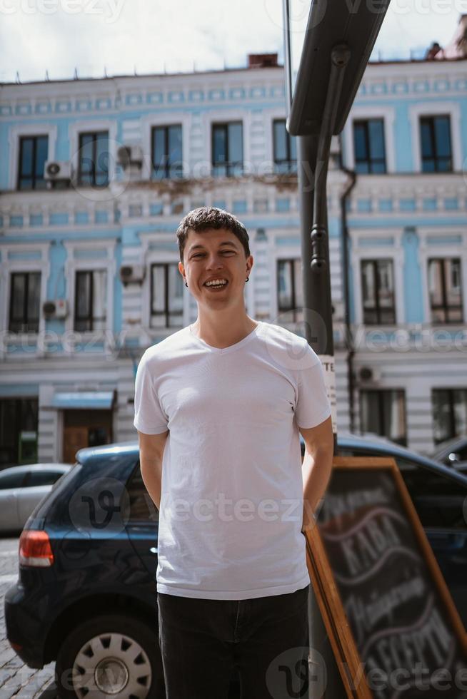 Man in gray t-shirt and jeans over city street background photo