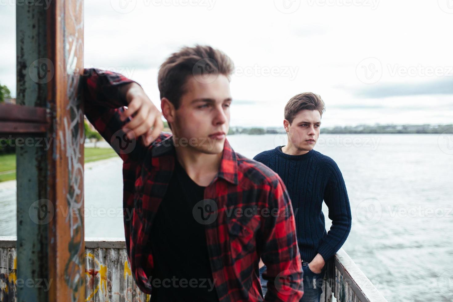 dos chicos están parados en un edificio abandonado en el lago foto