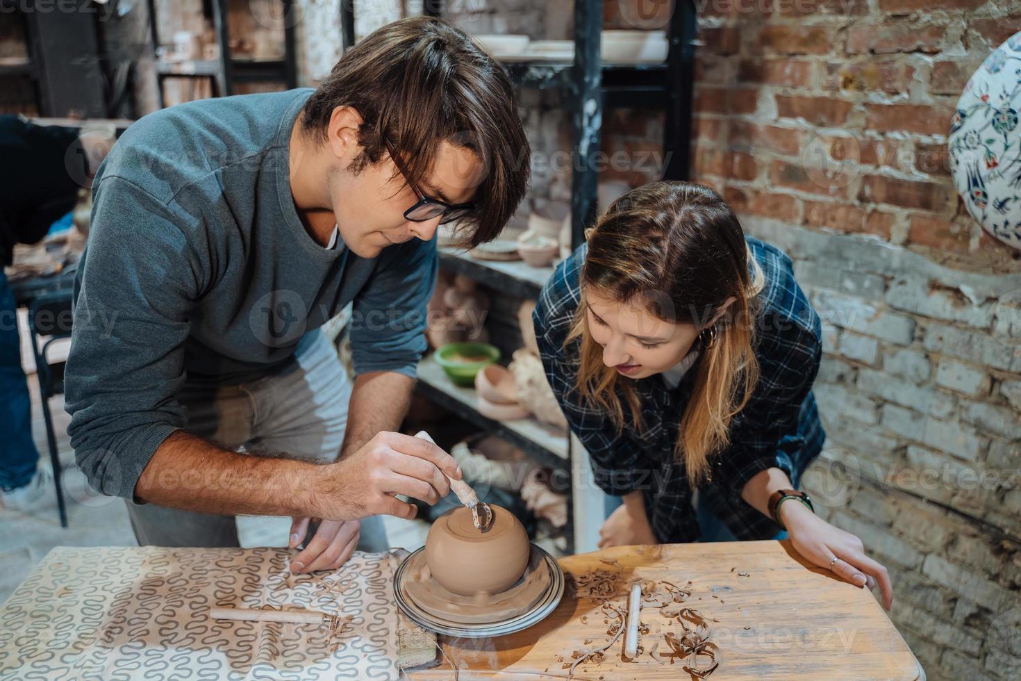 Making a handmade clay pot in the workshop. Pottery lesson, hobby. photo