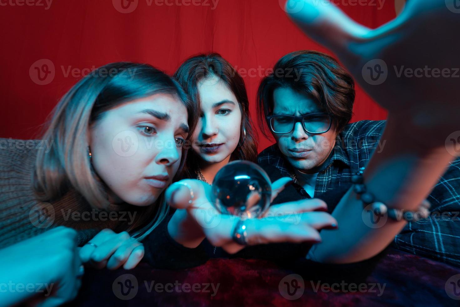 Group of people and woman fortune teller with crystal ball photo