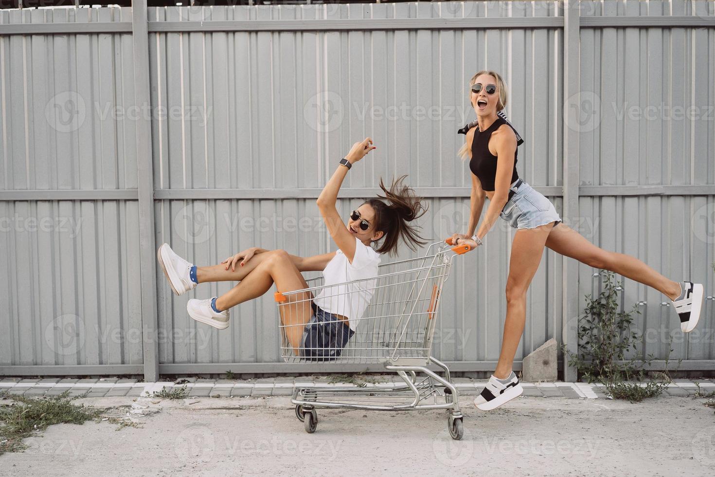 Friends ride on carts, near the supermarket photo