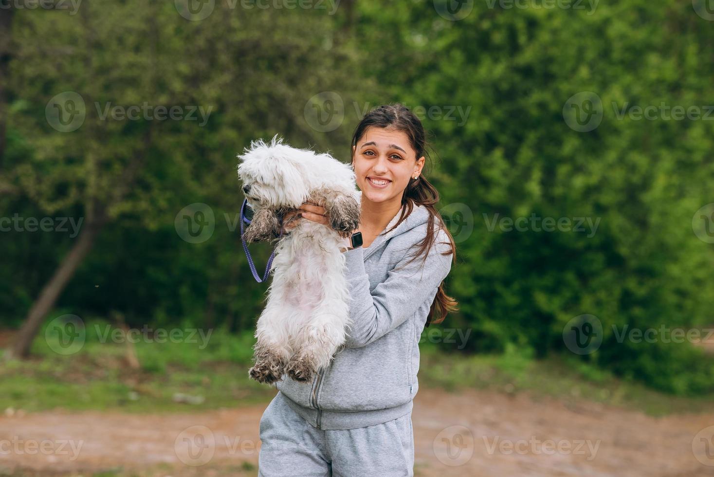 Beautiful woman holding a dog in her arms photo