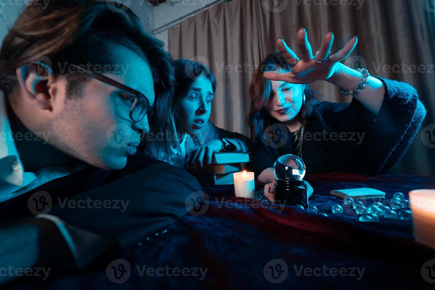 grupo de personas y mujer adivina con bola de cristal foto